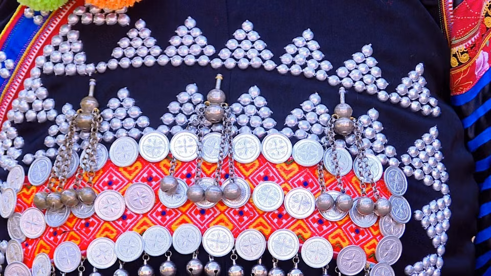 Des motifs brodés et des bijoux en argent sont attachés aux chemises des femmes Ha Nhi. Photo: VNA