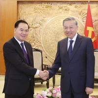 Le secrétaire général du Comité central du Parti communiste du Vietnam (PCV), To Lam (droite) et Thongsalith Mangnomek, secrétaire du Comité central du Parti populaire révolutionnaire lao (PPRL), président du Bureau du Comité central du PPRL. Photo : VNA