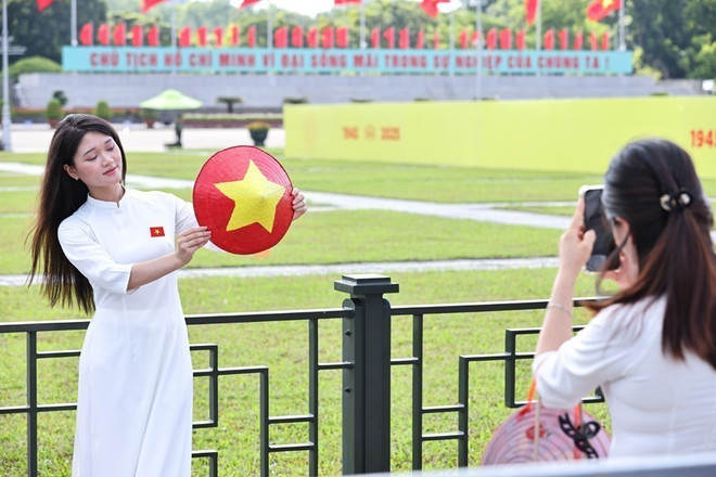 De jeunes femmes revêtent l'ao dai, la tenue traditionnelle vietnamienne, pour célébrer le 80e anniversaire de la Révolution d'août et de la Fête nationale. Photo : VNA check-in-1-ava.jpg