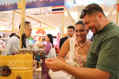 Des visiteurs étrangers apprécient les produits artisanaux présentés lors de l’événement. Photo: VNA