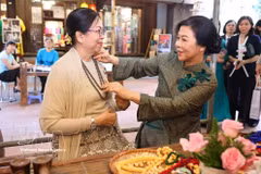 Mme Ngo Phuong Ly, épouse du secrétaire général du Parti et président de la République To Lam (droite) et Mme Kyu Kyu Hla, épouse du président birman Min Aung Hlaing, visitent le village de la soie de Van Phuc. Photo: VNA