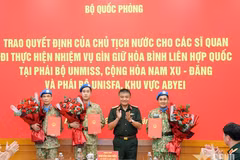 Le général de corps d’armée Nguyen Van Hien remet la décision du Président à trois officiers chargés de participer à des missions de maintien de la paix des Nations Unies. Photo : www.qdnd.vn