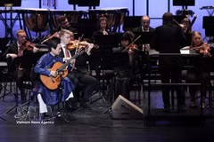 L'artiste Dang Ngoc Long et l'Orchestre symphonique de Tübingen (Allemagne) se produisent lors du concert « Une rhapsodie de deux mondes » au théâtre Ho Guom (Hanoï) en décembre 2025. Photo : VNA