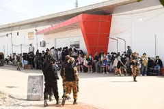 Les forces de l'ordre du ministère lao de la Sécurité publique escortent les suspects arrêtés lors du démantèlement d'un réseau d'escroquerie en ligne et de jeux d'argent sur Internet à Vientiane. Photo: VNA
