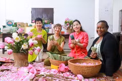 Des visiteurs découvrent l'art de parfumer le thé au lotus de Quảng An. Photo: VNA