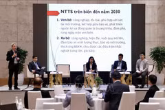 Des délégués discutent lors du colloque. Photo: VNA