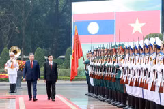 Les dirigeants To Lam et Thongloun Sisoulith passent en revue la garde d'honneur de l'Armée populaire vietnamienne. Photo: VNA