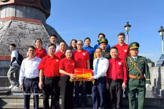 Duong Ngoc Duc, secrétaire du Comité du Parti et président du Conseil populaire de la commune de Lung Cu, remet à Do Thi Thu Thao le drapeau national ayant flotté sur le mât national de Lung Cu. Do Thi Thu Thao est membre du Présidium du Comité central du Front de la Patrie du Vietnam, présidente du Comité central de la Croix-Rouge vietnamienne, ainsi que députée à la 16e Assemblée nationale. Photo : VNA