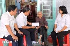 Remise des cadeaux du Parti et de l'État aux bénéficiaires à leur domicile. Photo: VNA