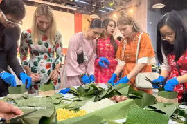 L'atelier de banh chung - gâteau emblématique du Nouvel An lunaire confectionné à base du riz gluant, de haricots mungo réduits ,de viande de porc, enveloppé dans des feuilles de dong, a captivé près de 200 jeunes. Photo : VNA