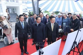 Le vice-PM et ministre des AE Bùi Thanh Son et des délégués lors de l'exposition de photos 30 ans d'adhésion du Vietnam à l'ASEAN. Photo: VNA