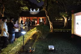 Des touristes participent à l'excursion « Découvrez la nuit à Van Mieu-Quoc Tu Giam ». (Photo : nhandan.vn)