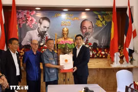 L’ambassadeur vietnamien, Pham Viet Hung (à droite) remet un cadeau à ,Nguyen Van Tri, président de l'Association des Vietnamiens de Sa Kaeo. Photo : VNA