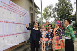 La cheffe du bureau de vote n°5 de la commune de Quy Mong, dans la province de Lao Cai, présente les candidats afin d’aider les habitants à mieux les connaître. Photo: VNA