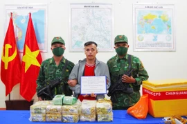 Le suspect (au centre), les pièces à conviction et le véhicule ont été remis à la police provinciale d'An Giang pour une enquête plus approfondie. Photo : VNA