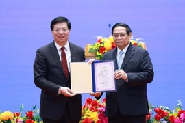 Le professeur et docteur Qiu Yong (gauche) remet le titre de « professeur honoraire » de l'Université Tsinghua au Premier ministre Pham Minh Chinh. Photo : VNA