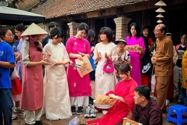 Des touristes sud-coréens s'immergent dans les peintures folkloriques de Dong Ho dans l'ancien village de Duong Lam, à Hanoï. Photo: VietnamPlus