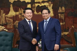 Le Premier ministre Pham Minh Chinh (droite) et Saleumxay Kommasith, vice-Premier ministre et chef de la Commission centrale de réforme des entreprises publiques du Parti populaire révolutionnaire lao. Photo: VNA