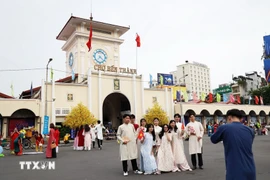 Des habitants et des touristes prennent des photos souvenirs au marché Ben Thanh. Photo : VNA
