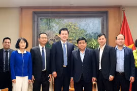 Le vice-Premier ministre Nguyên Chi Dung (4e de droite à gauche) prend la photo avec la délégation de Qualcomm. Photo: VNA