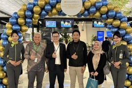 Un représentant de Vietnam Airlines en Indonésie (troisième à partir de la gauche) avec des passagers à l'aéroport international Soekarno-Hatta, en Indonésie. Photo : VNA