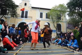 Les visiteurs internationaux découvrent des activités culturelles et des jeux folkloriques à Hanoi. (Photo : Thanh Dat/https://nhandan.vn/)