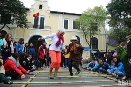 Les visiteurs internationaux découvrent des activités culturelles et des jeux folkloriques à Hanoi. (Photo : Thanh Dat/https://nhandan.vn/)