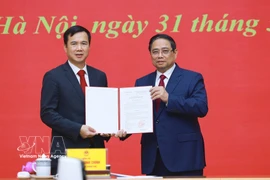Le Premier ministre Pham Minh Chinh (à droite) remet la décision de nomination de Bui The Duy, membre suppléant du Comité central du Parti et vice-président de l’Académie des sciences et des technologies du Vietnam, au poste de directeur de l’Université nationale du Vietnam à Hanoï. Photo : VNA