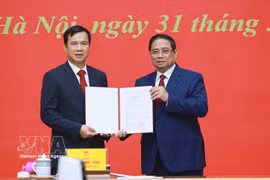 Le Premier ministre Pham Minh Chinh (à droite) remet la décision de nomination de Bui The Duy, membre suppléant du Comité central du Parti et vice-président de l’Académie des sciences et des technologies du Vietnam, au poste de directeur de l’Université nationale du Vietnam à Hanoï. Photo : VNA