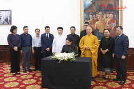 La vice-présidente et secrétaire générale du Comité central du FPV Ha Thi Nga écrit au registre de condoléance pour le président de l'Assemblée nationale lao, Saysomphone Phomvihane. Photo : daidoanket.vn.jpg
