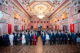 Les délégués et les invités ont procédé à la cérémonie de lever du drapeau lors de l’événement. Photo: VNA