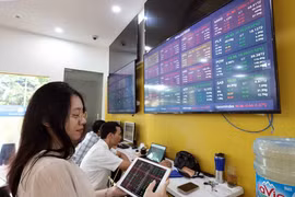 Des clients effectuent des transactions chez la société boursière de Bao Viêt (Bao Viêt Securities). Photo: VNA