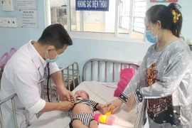 Un médecin de l'hôpital pour enfants No1 de Ho Chi Minh-Ville examine un enfant atteint de rougeole. (Photo : VNA)