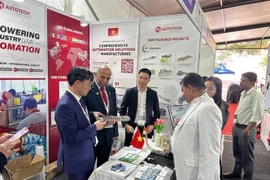 Le conseiller commercial de l'ambassade du Vietnam en Inde, Bui Trung Thuong (premier à gauche), et le consul honoraire du Vietnam à Bangalore, N. Srinivasa Murthy, visitent le stand vietnamien. Photo fournie par l’Office du commerce du Vietnam. VNA.