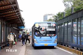 Des passagers prennent un bus dans la rue Ham Nghi, à Hô Chi Minh-Ville. Photo: VNA