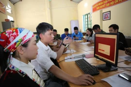 Instructions aux résidents du village de Son Ha, commune de Bat Xat, sur la manière de soumettre des demandes en ligne via le portail des services publics. Photo: VNA
