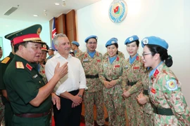 Le général de corps d’armée Hoàng Xuân Chiên, vice-ministre de la Défense et chef du Comité de pilotage du ministère sur la participation aux opérations de maintien de la paix de l’ONU, et Hugh Jeffrey, secrétaire général adjoint à la Défense de l’Australie échangent avec des femmes officiers de la Force vietnamienne de maintien de la paix. Photo : VNA