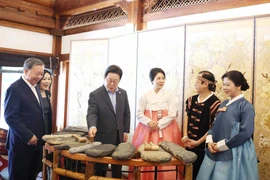 Le secrétaire général Tô Lâm et son épouse présentent l'art lithophone vietnamien au président sud-coréen Lee Jae Myung et à son épouse. Photo : VNA