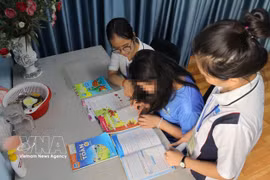 Des collaborateurs sociaux accompagnent T.A.T. (née en 2013) dans ses activités d’apprentissage et de vie quotidienne au sein de la maison d’accueil temporaire du modèle "Bồ Công Anh", située dans le quartier de Hạnh Thong, à Hô Chi Minh-Ville. Photo: VNA