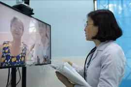 Un médecin du centre médical du quartier 16, district de Go Vap, à Ho Chi Minh-Ville, effectue un examen médical en ligne pour un patient. (Photo : VNA)