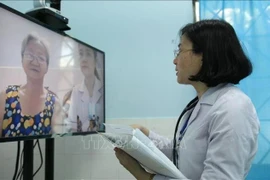 Un médecin du centre médical du quartier 16, district de Go Vap, à Ho Chi Minh-Ville, effectue un examen médical en ligne pour un patient. (Photo : VNA)