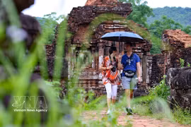 Les touristes internationaux admirent la beauté du site archéologique Cham de My Son (à Da Nang). Photo : VNA
