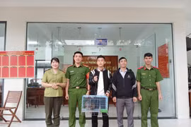 Trinh Quoc Phu (au milieu) remet volontairement l'oiseau sauvage rare aux autorités du quartier de Quy Nhon Nam. Photo : https://baogialai.com.vn/