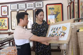 Des visiteurs admirent les estampes de Dong Ho. Photo: VNA
