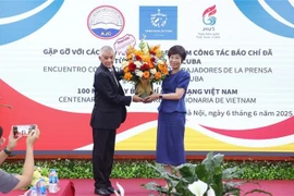 Le représentant de l'agence de presse Prensa Latina au Vietnam offert des fleurs à la directrice générale de VNA, Vu Viêt Trang à l'occasion de la Journée de la presse révolutionnaire vietnamienne. Photo : VNA