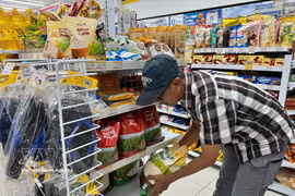 Un habitant choisit d’acheter du riz dans un supermarché Indomaret à Jakarta. Photo : VNA