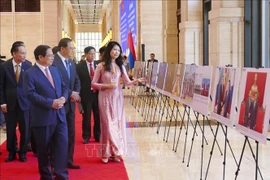 Le Premier ministre vietnamien Pham Minh Chinh et son homologue lao Sonexay Siphandone lors de l'exposition de photos. Photo : VNA