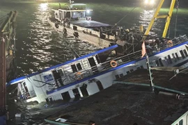 Le bateau touristique Vinh Xanh 58, qui a chaviré, a été récupéré et remorqué jusqu'à la côte le 20 juillet pour une enquête plus approfondie. (Photo : VNA)