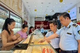 Inspecteurs du marché lors d'un contrôle de routine dans un magasin d'or de l'arrondissement de Cầu Giấy, Hà Nội. Photo / VNA