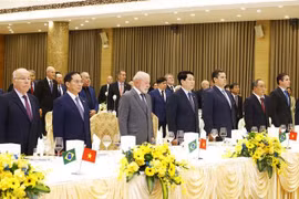 Le président brésilien Luiz Inacio Lula da Silva (devant, troisième à partir de la gauche), le président de l'État Luong Cuong (devant, quatrième à partir de la gauche) et des responsables lors du banquet à Hanoï le 28 mars (Photo : VNA)